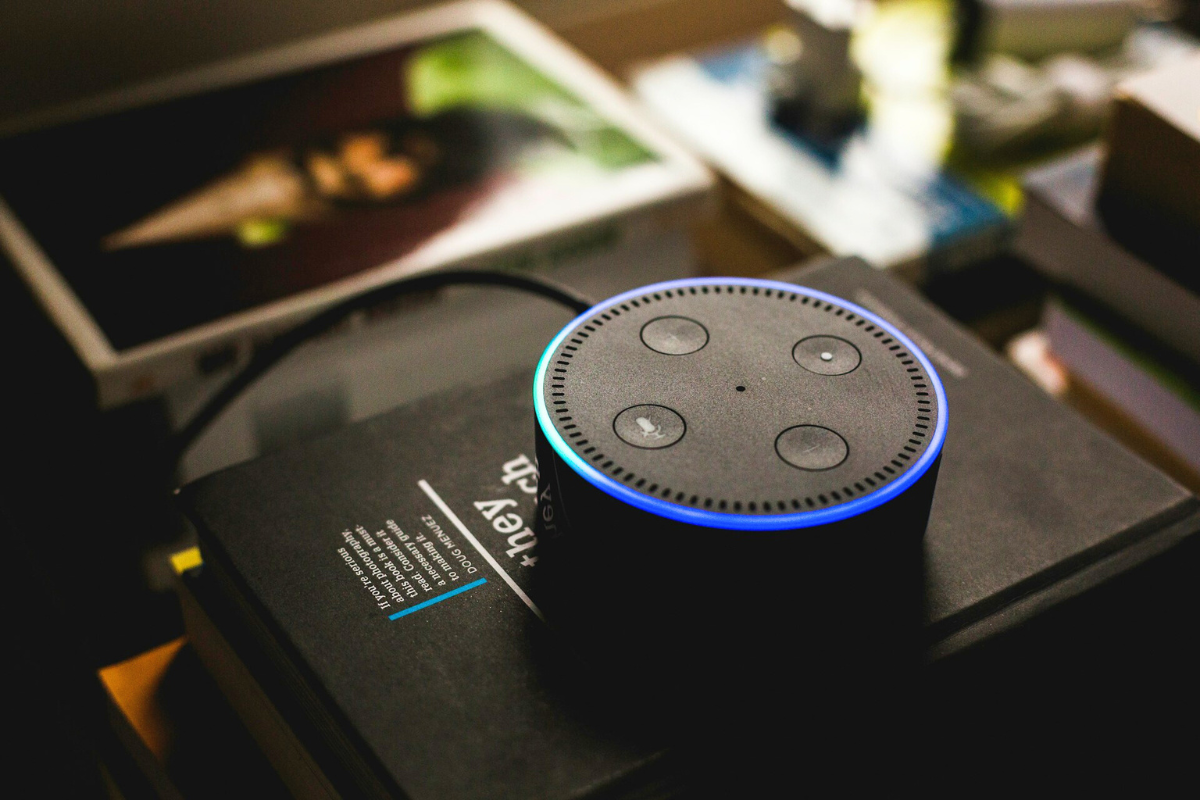 An Amazon Echo Dot on a stack of books.