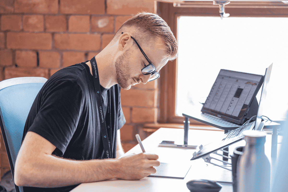 Aled Nelmes working at a laptop in the Lumen SEO office in Cardiff.